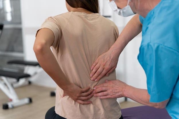 Doctor examines patient for back pain